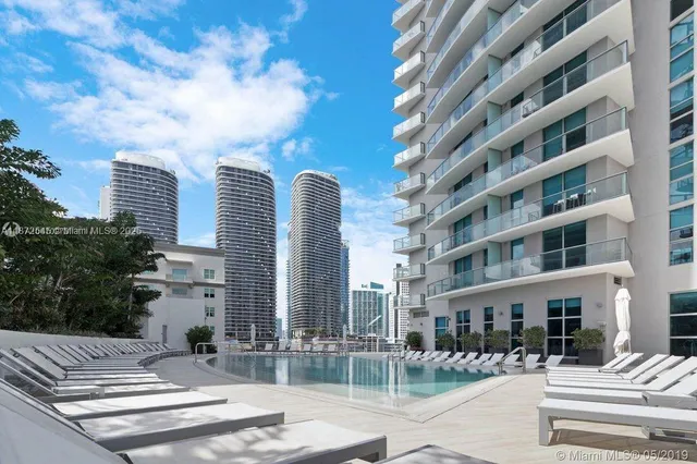 a front view of a building with street view and plants