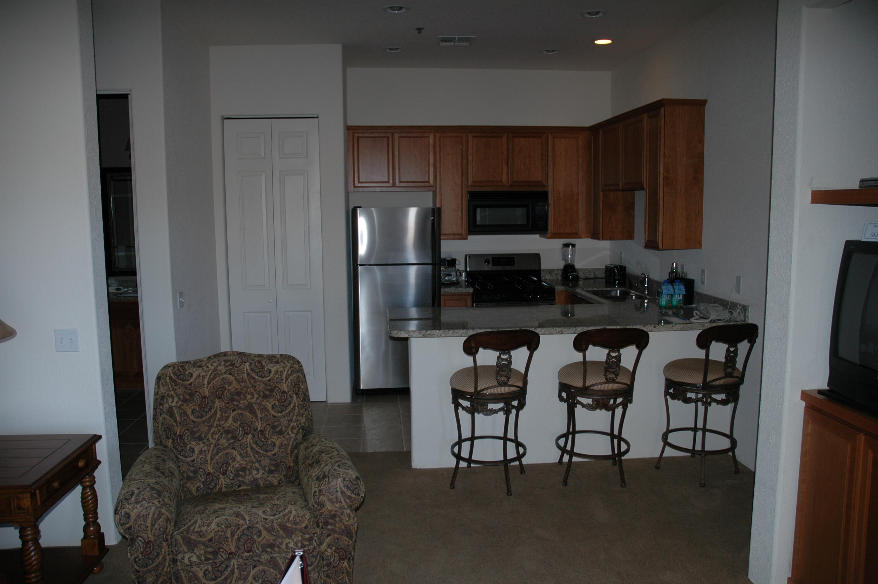 50740 Santa Rosa Plaza, Unit 5 La Quinta, CA 92253 - Photo 7 of 17 a kitchen with stainless steel appliances kitchen island granite countertop a refrigerator and a stove top oven