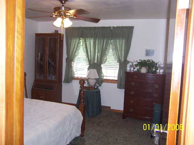 6629 Riverview Road Thomson, IL 61285 - Photo 6 of 9 a bedroom with a bed and a chandelier