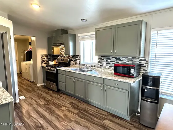 a kitchen with a stove and wooden floor