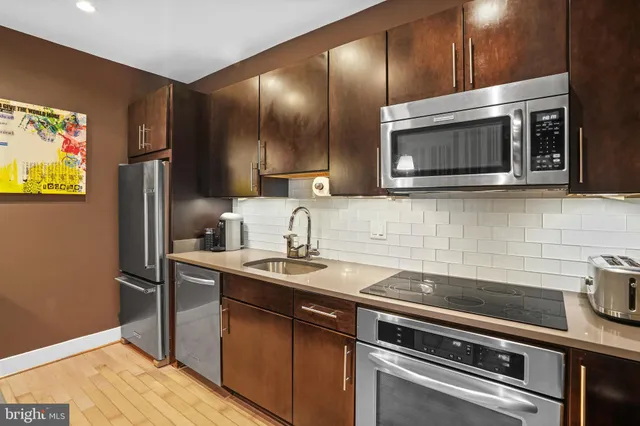 a kitchen with stainless steel appliances granite countertop a sink and a microwave