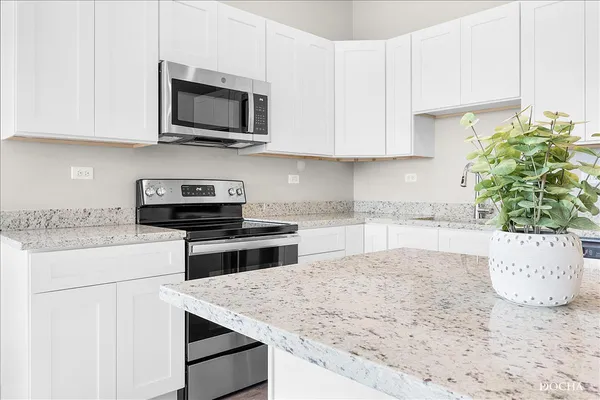 a kitchen with a stove and a white cabinets