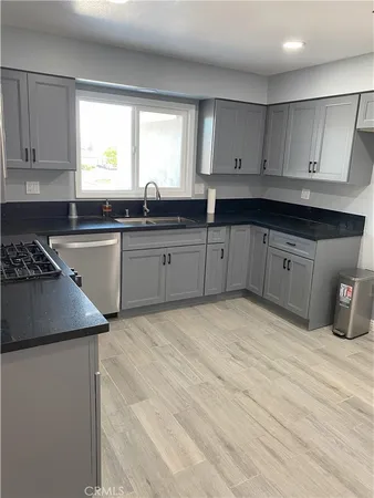 a kitchen with granite countertop a stove sink and cabinets