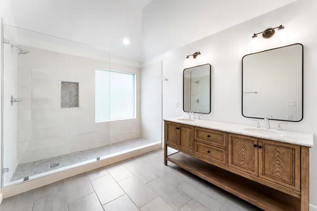 a spacious bathroom with a double vanity sink and a mirror