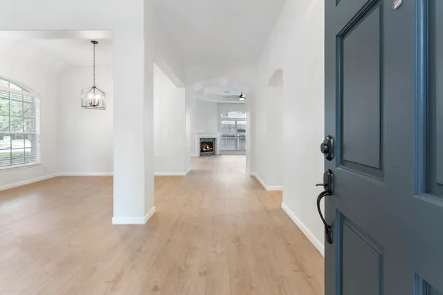 a view of a hallway with wooden floor and a living room