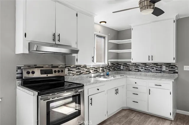 a kitchen with white cabinets and appliances