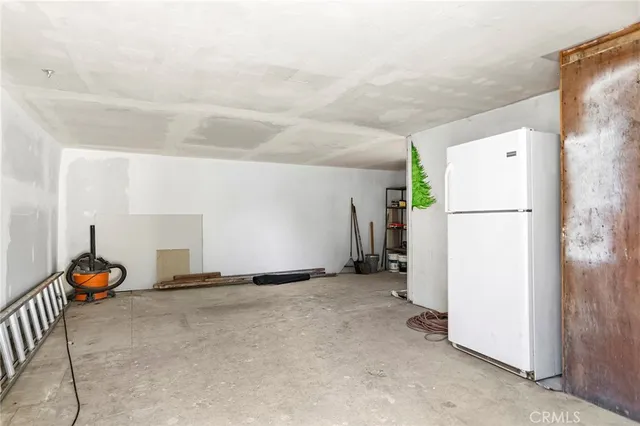 a view of a livingroom with furniture and a refrigerator