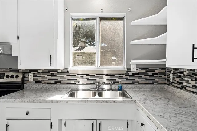 a kitchen with a sink and a stove top oven
