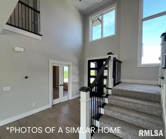 a living room with stainless steel appliances kitchen island granite countertop a couch a dining table and chairs with wooden floor