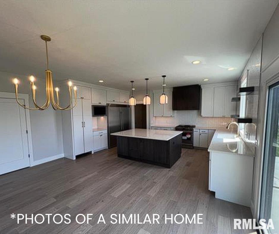 6414 Pelican Street Bettendorf, IA 52722 - Photo 31 of 57 a living room with stainless steel appliances kitchen island granite countertop a couch a dining table and chairs with wooden floor