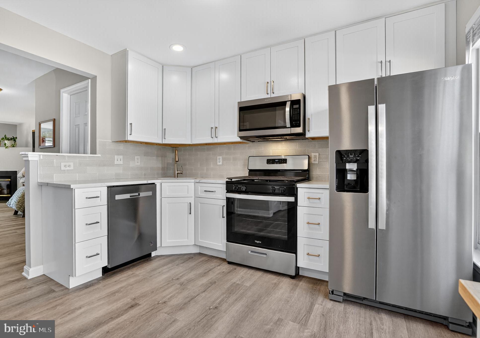 45445 Timber Trail Square Sterling, VA 20164 - Photo 6 of 38 a kitchen with cabinets stainless steel appliances and wooden floor