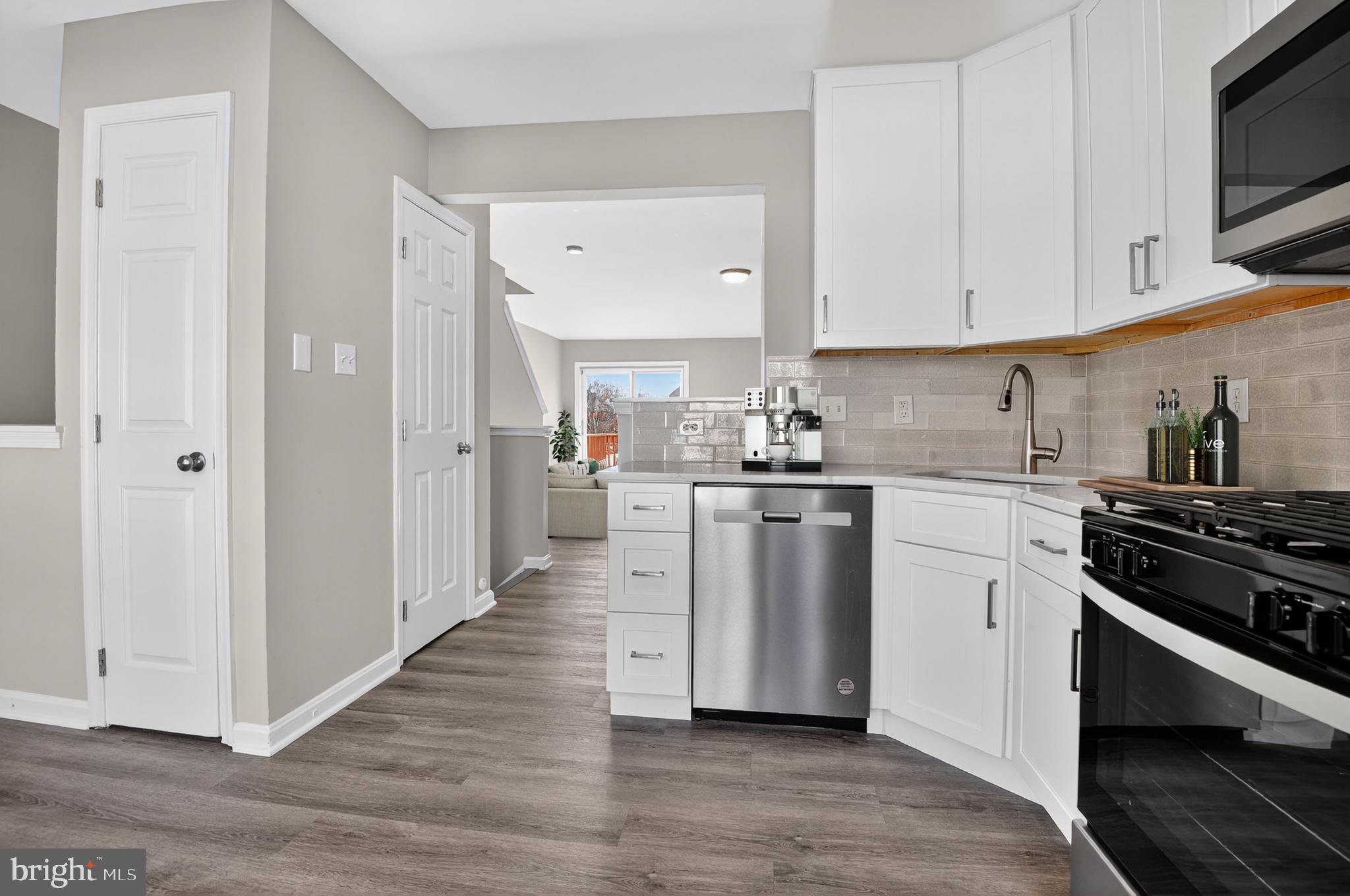45445 Timber Trail Square Sterling, VA 20164 - Photo 10 of 38 a kitchen with white cabinets and appliances