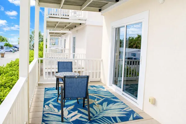 a view of a balcony with chairs and a potted plant