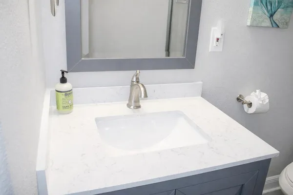 a bathroom with a granite countertop toilet and a sink