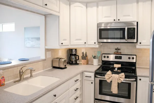 a kitchen with stainless steel appliances granite countertop a sink stove and microwave