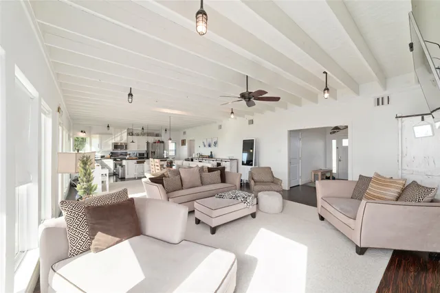 a dining hall with stainless steel appliances kitchen island granite countertop a dining table chairs and view living room