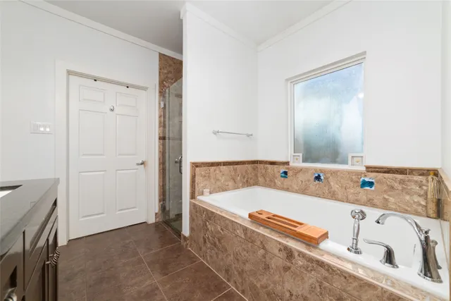 a bathroom with a sink vanity granite tub and a mirror