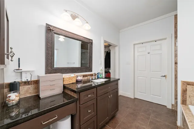 a bathroom with a granite countertop sink and a mirror