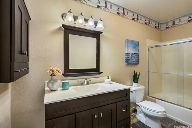 a bathroom with a sink vanity mirror and toilet