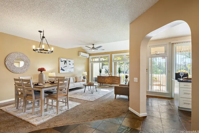 a living room with lots of furniture a rug and a chandelier