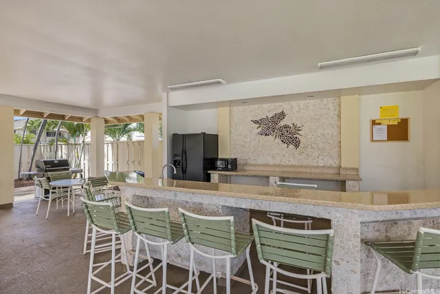 a dining hall with stainless steel appliances granite countertop a stove and a refrigerator