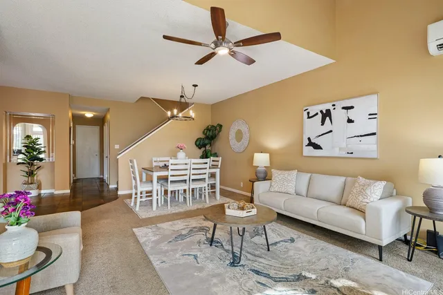 a living room with furniture kitchen view and a rug