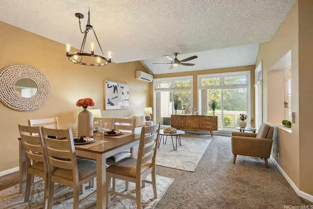 a living room with dining table a couch and a chandelier