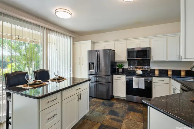 a kitchen with stainless steel appliances granite countertop a stove refrigerator and microwave
