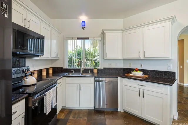 a kitchen with white cabinets and sink