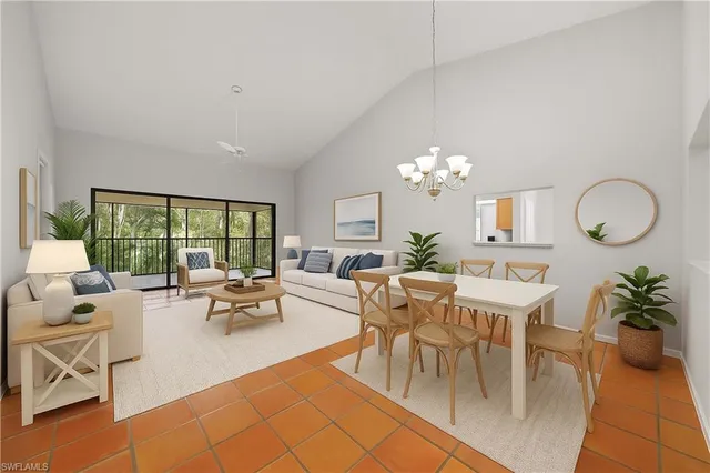 a dining room with furniture a large window and a chandelier