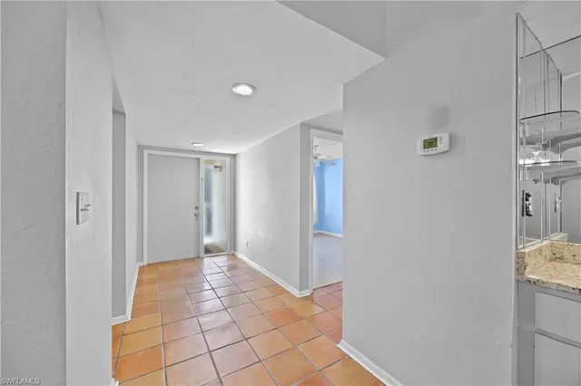 a view of a hallway to a room with windows