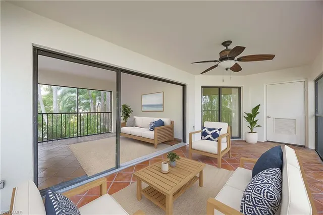 a living room with furniture and a floor to ceiling window