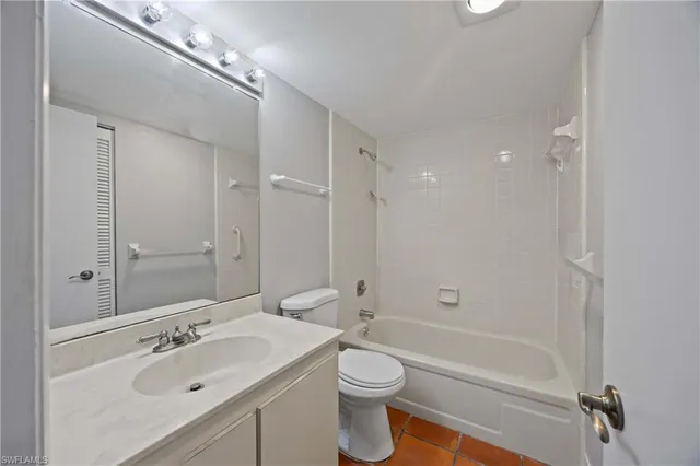 a bathroom with a bathtub shower sink mirror vanity and toilet