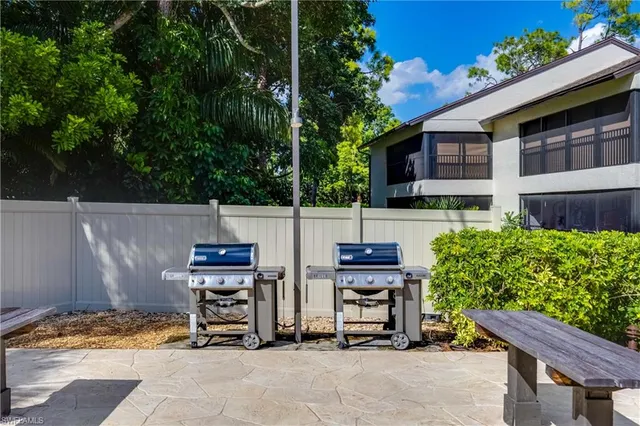 a backyard of a house with barbeque oven and outdoor seating