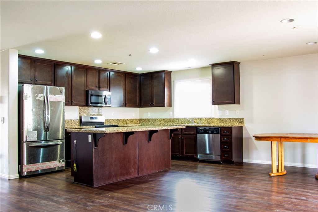1325 Sunset Avenue Perris, CA 92571 - Photo 8 of 27 a large kitchen with stainless steel appliances granite countertop a stove and a refrigerator