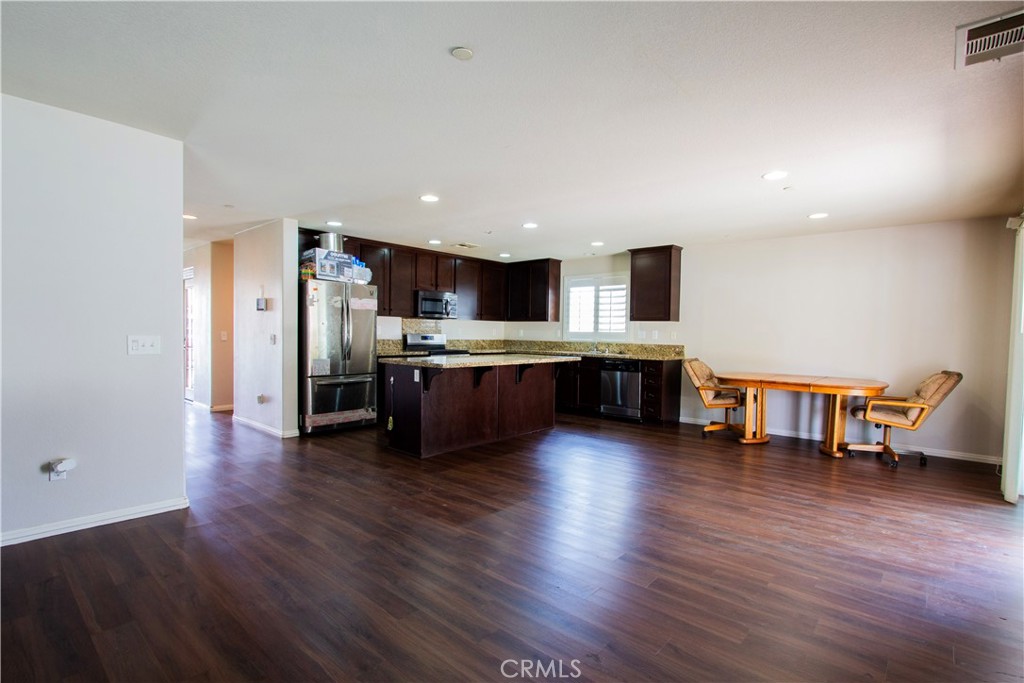 1325 Sunset Avenue Perris, CA 92571 - Photo 9 of 27 a large kitchen with stainless steel appliances granite countertop a large counter top and a wooden floors