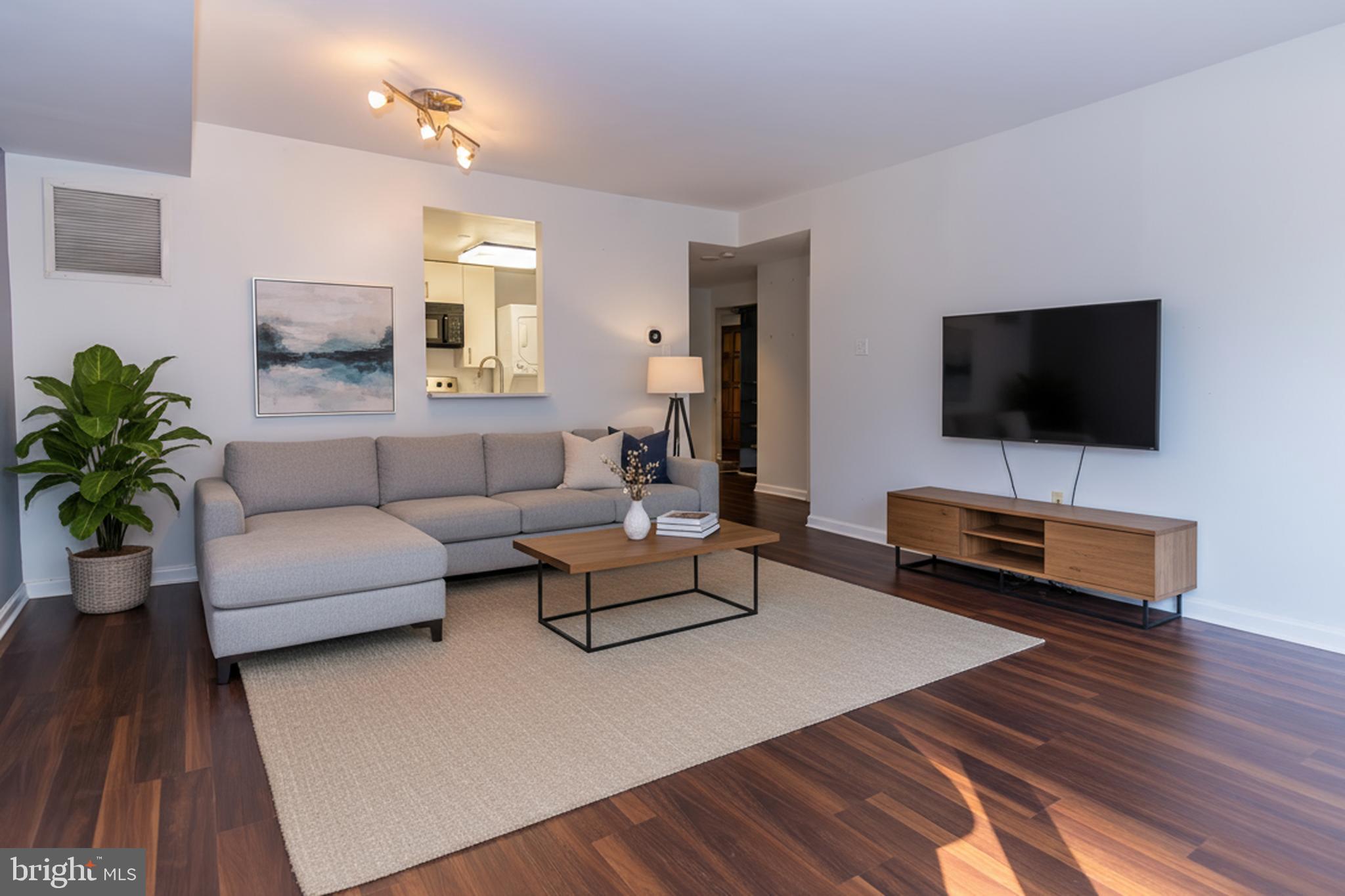 1530 Key Boulevard, Unit 205 Arlington, VA 22209 - Photo 11 of 33 a living room with furniture and a flat screen tv