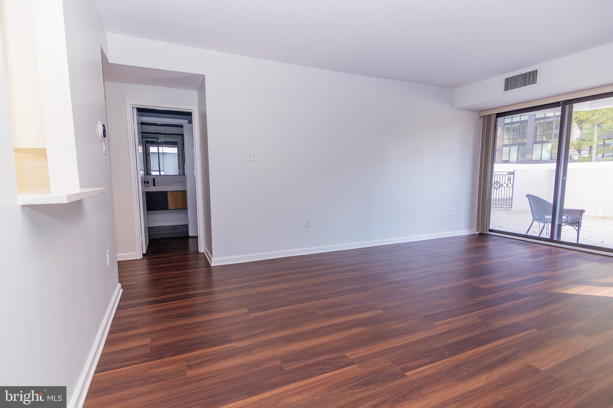 1530 Key Boulevard, Unit 205 Arlington, VA 22209 - Photo 13 of 33 a view of an empty room with wooden floor and a window