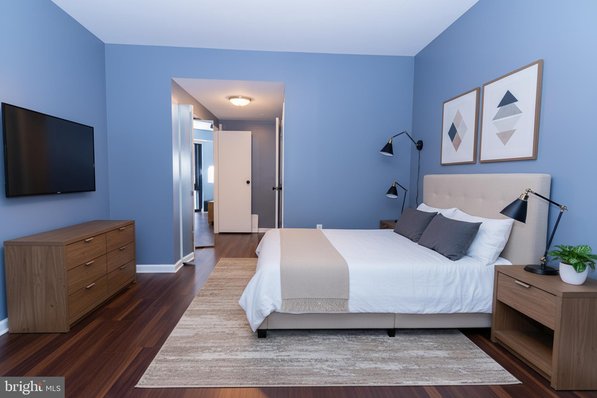 1530 Key Boulevard, Unit 205 Arlington, VA 22209 - Photo 14 of 33 a bedroom with a bed and flat screen tv