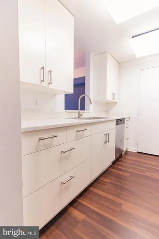 a view of a kitchen with wooden floor and electronic appliances