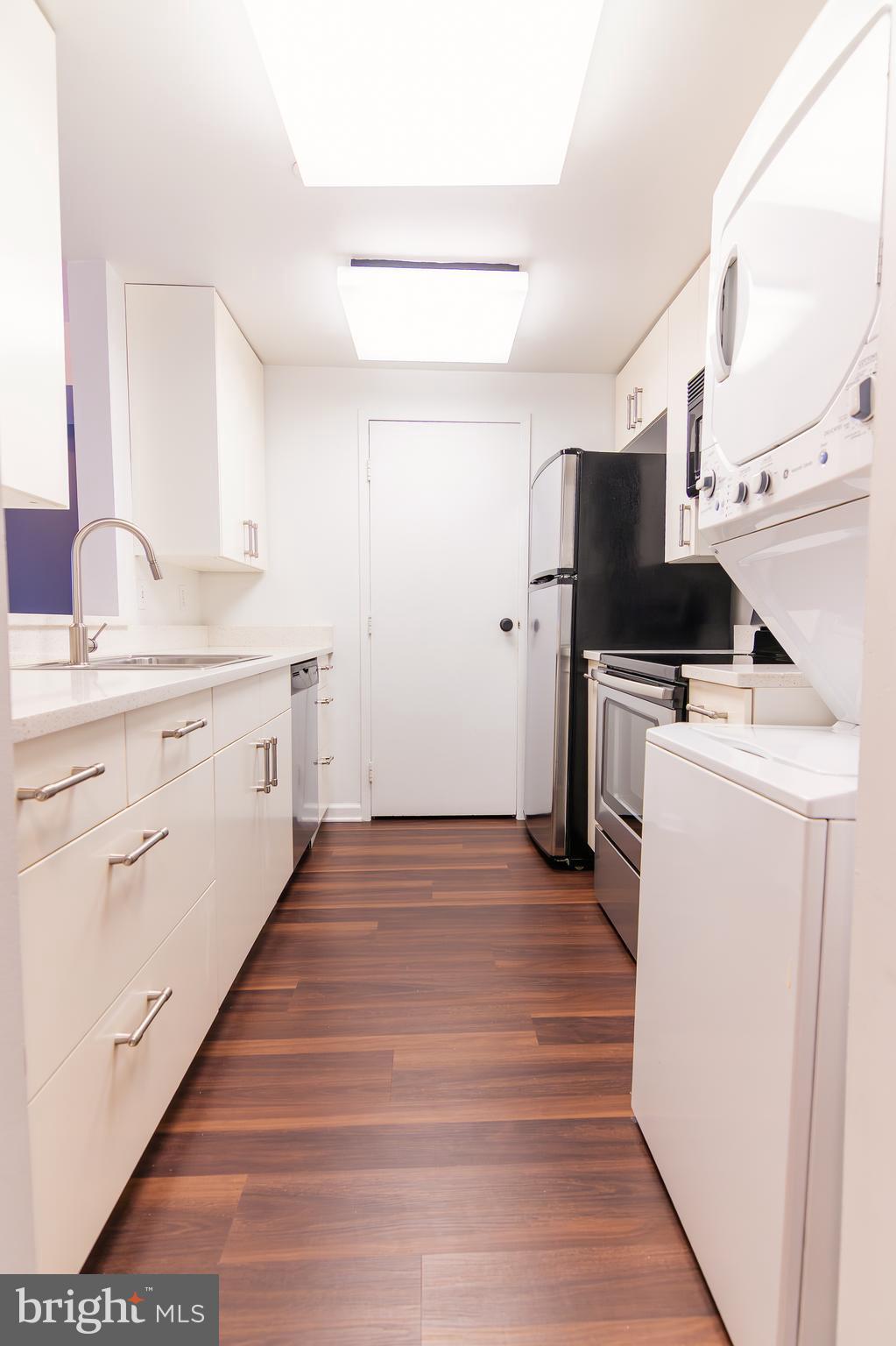 1530 Key Boulevard, Unit 205 Arlington, VA 22209 - Photo 29 of 33 a view of a kitchen with wooden floor and electronic appliances