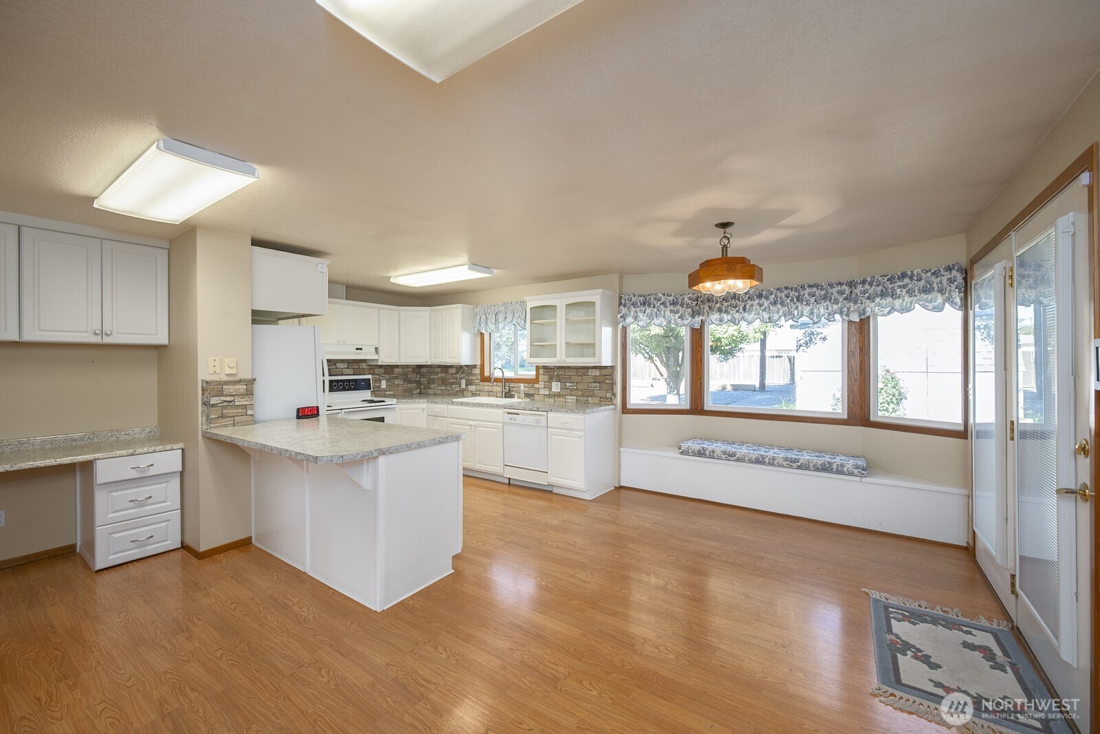 221 K Street Southwest Quincy, WA 98848 - Photo 13 of 38 a open kitchen with stainless steel appliances granite countertop a refrigerator a stove and white cabinets with wooden floor
