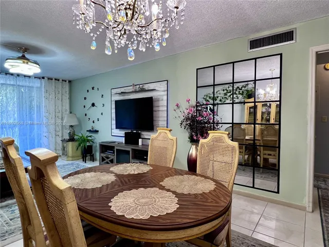 a living room with furniture a chandelier and a flat screen tv