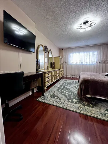 a bedroom with a large bed and a chandelier