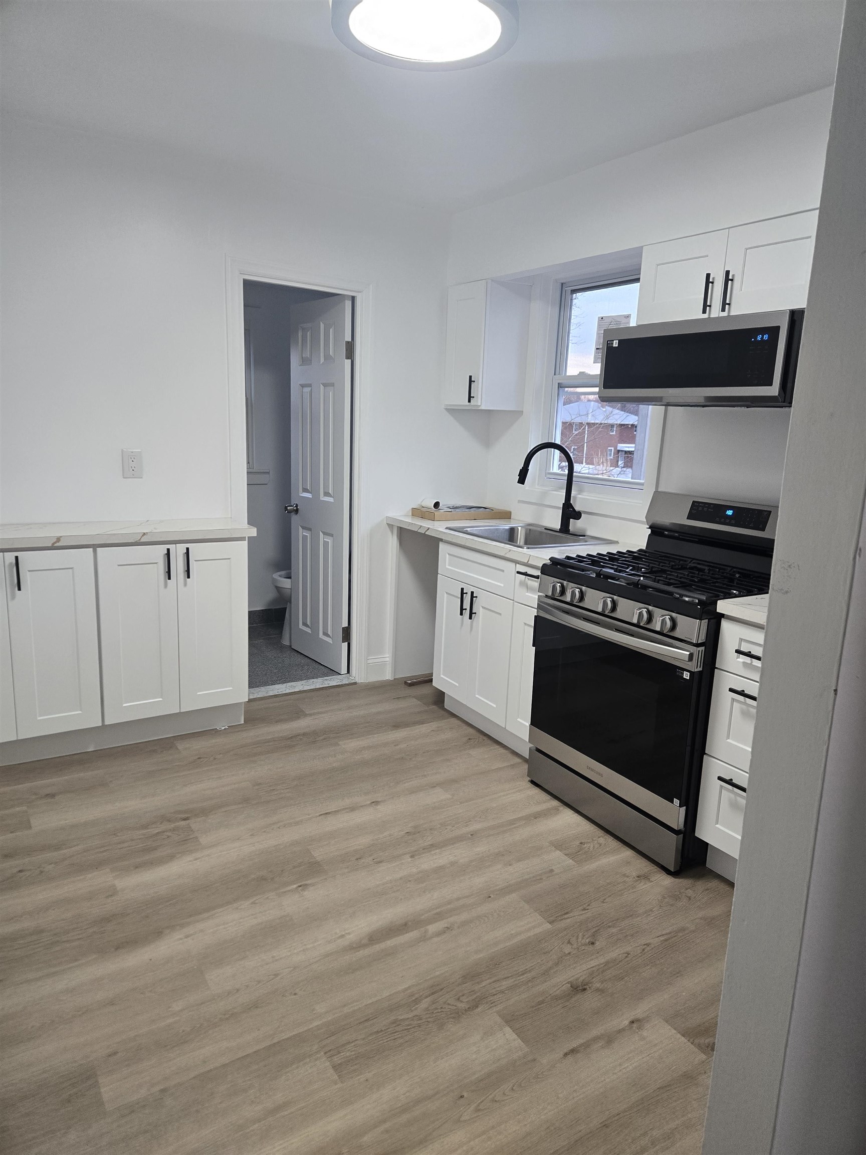 308 Lincoln Avenue, Unit 2 Lyndhurst, NJ 07071 - Photo 4 of 9 a kitchen with stainless steel appliances a stove a sink and a microwave