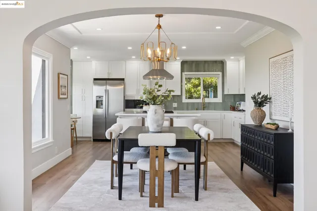 a view of a dining room with furniture a chandelier and wooden floor
