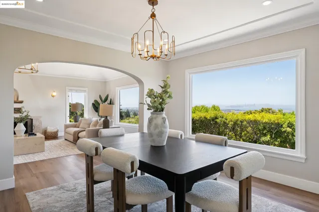 a dining room with furniture a chandelier and wooden floor
