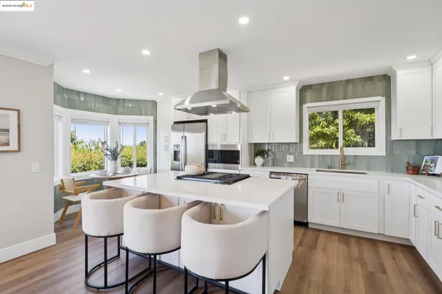 a kitchen that has a lot of cabinets stove top oven and couches