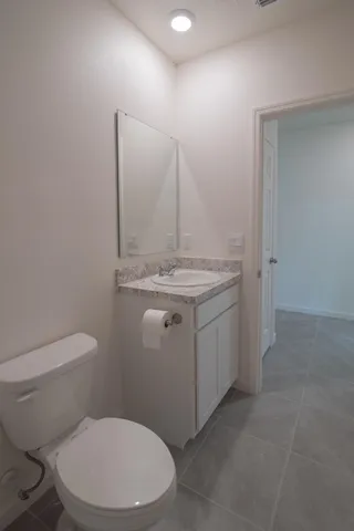 a bathroom with a granite countertop toilet and sink