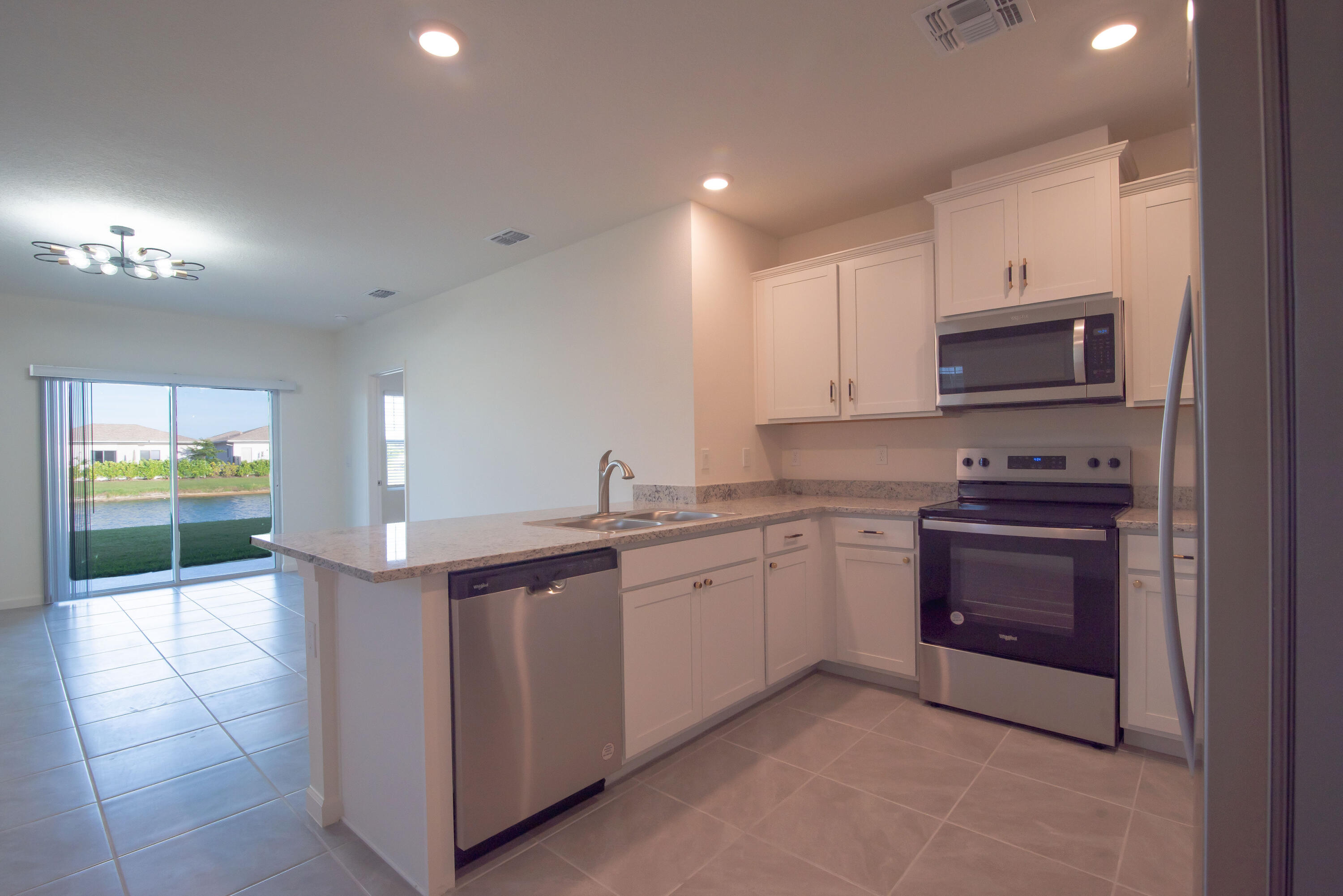 12152 Rimini Way Port St. Lucie, FL 34987 - Photo 2 of 24 a kitchen with stainless steel appliances granite countertop a stove and a sink